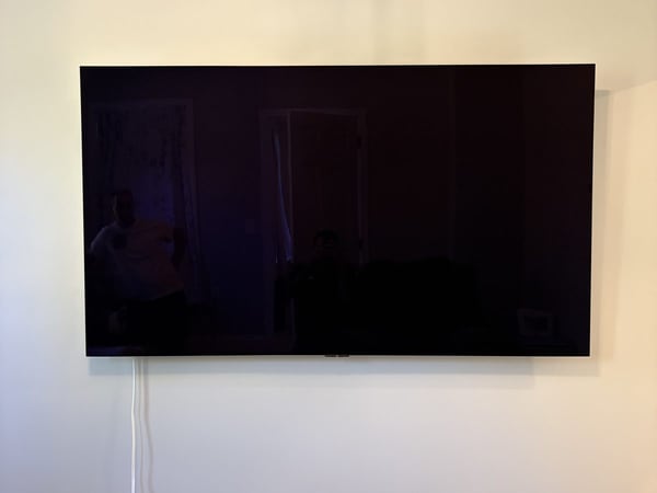 Large flat-screen television mounted on a pale living-room wall