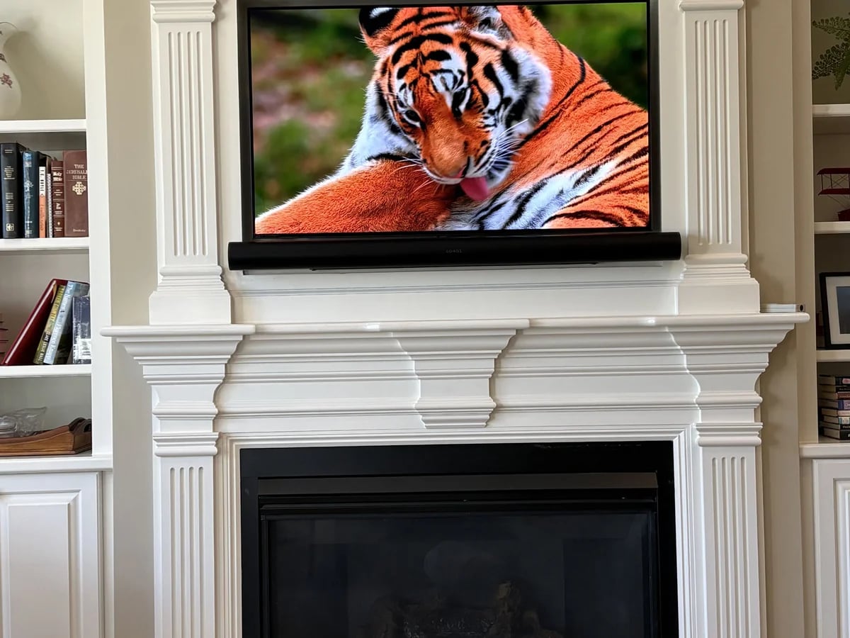 Large television integrated into custom fireplace built-ins in Shrewsbury, MA by J&S Audio Video Solutions