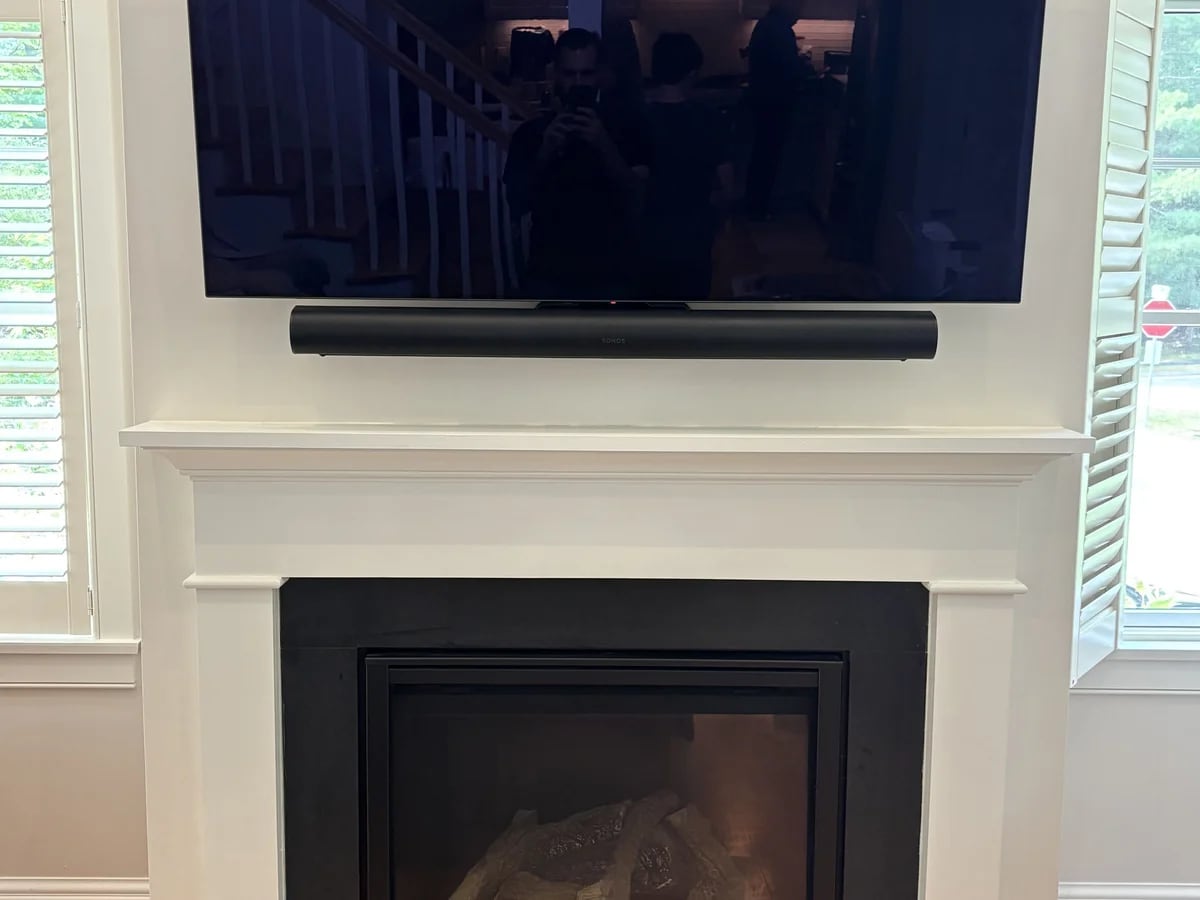 Television and soundbar mounted above a fireplace in Sherborn, MA by J&S Audio Video Solutions