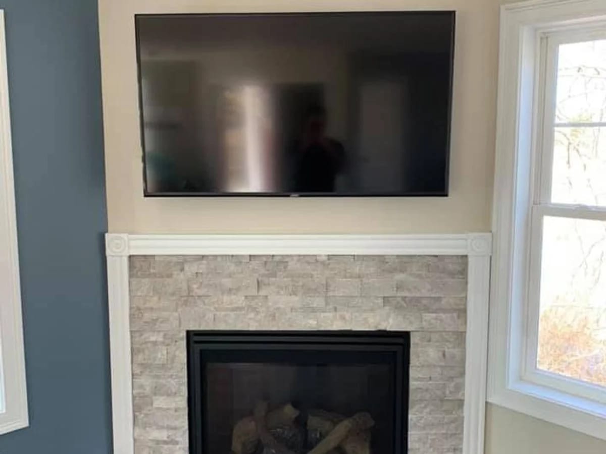 Television mounted above a fireplace in Sturbridge, MA by J&S Audio Video Solutions