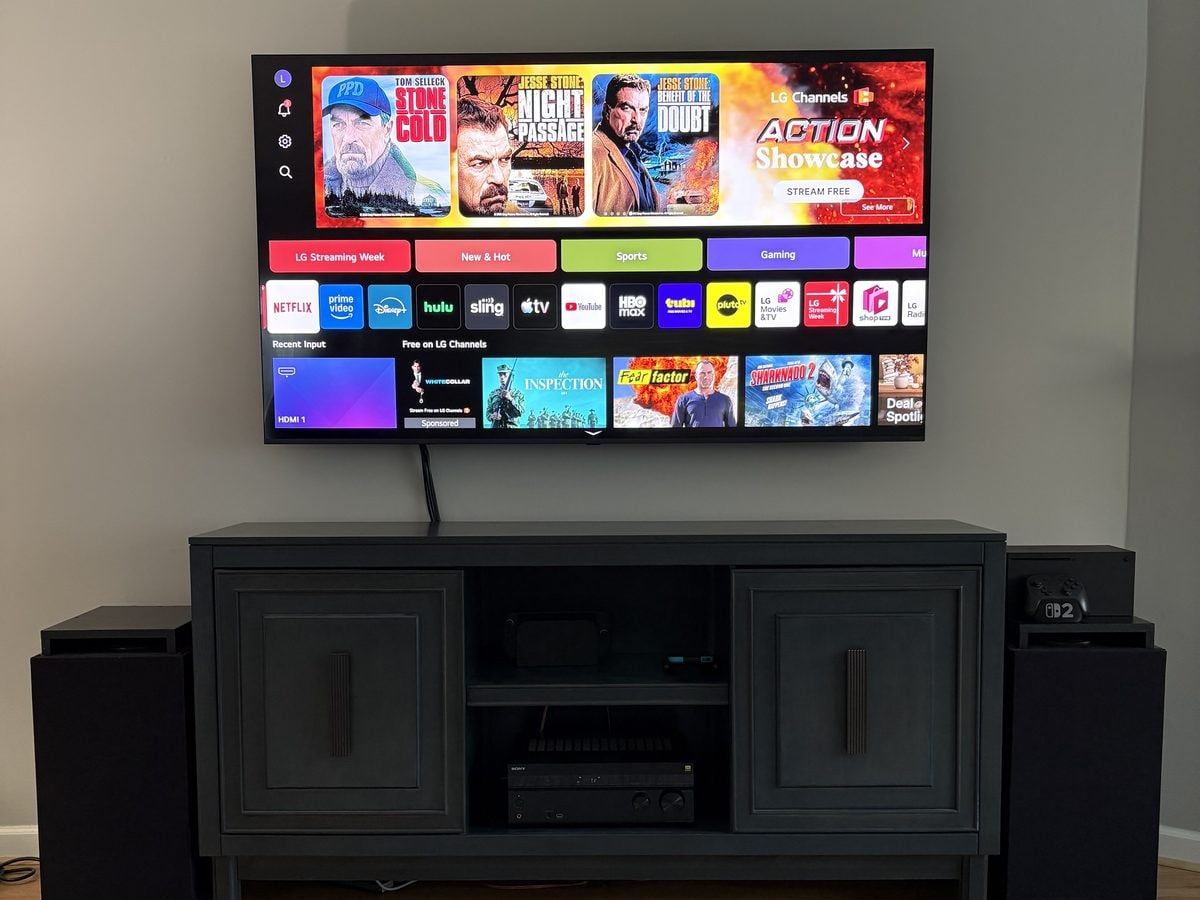 Wall-mounted television with speakers and an AV cabinet in Uxbridge, MA